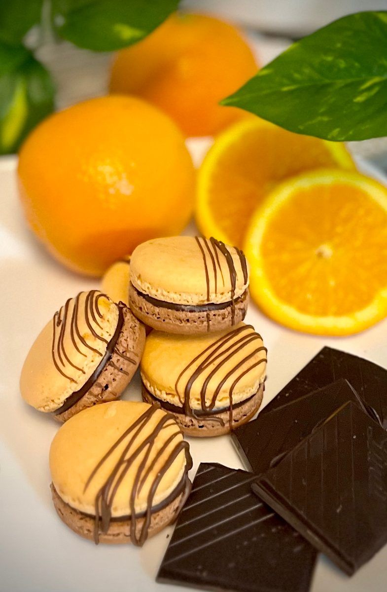 Orange chocolate macarons styled with fresh oranges and dark chocolate