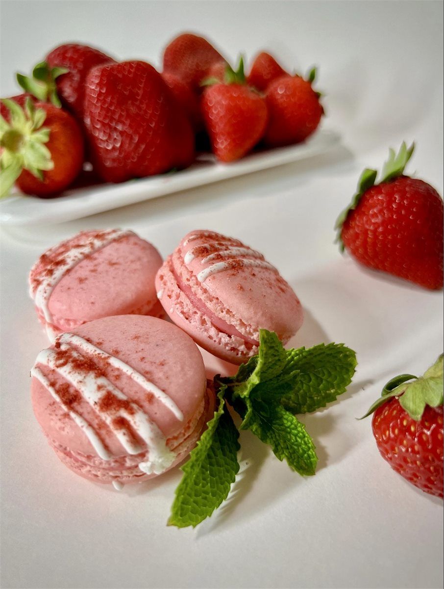 Pink strawberry macarons served with fresh strawberries and mint