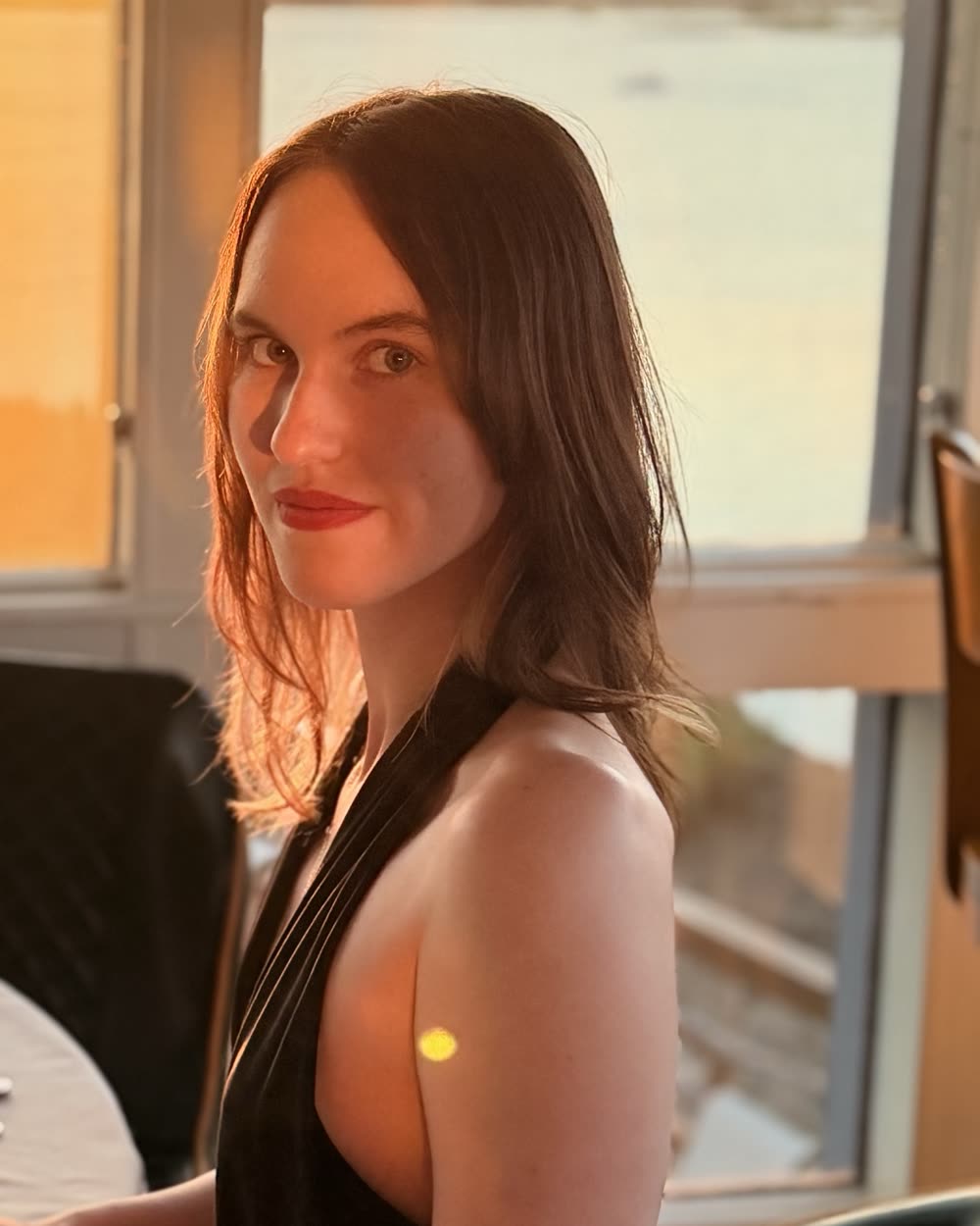 Zhenya at a window table in warm evening light