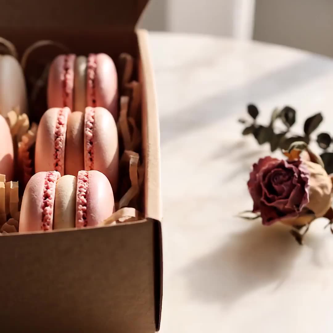 Gift boxes filled with pink and ivory macarons